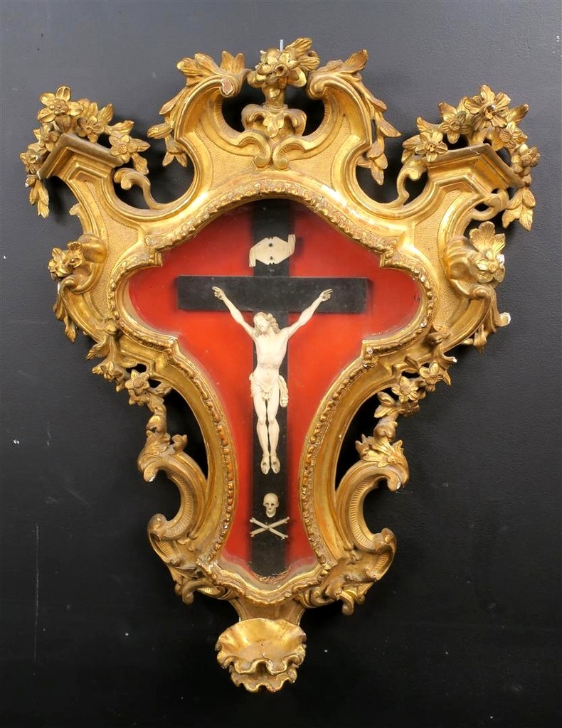 Christ en ivoire sculpté sous verre dans un riche encadrement en bois doré et sculpté de forme chantourné à décor floral