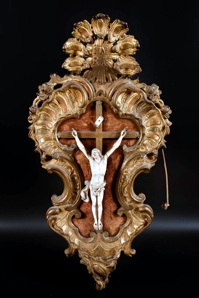 cadre en bois doré sculpté de motifs Louis XV présentant un crucifix en nivoire en son centre