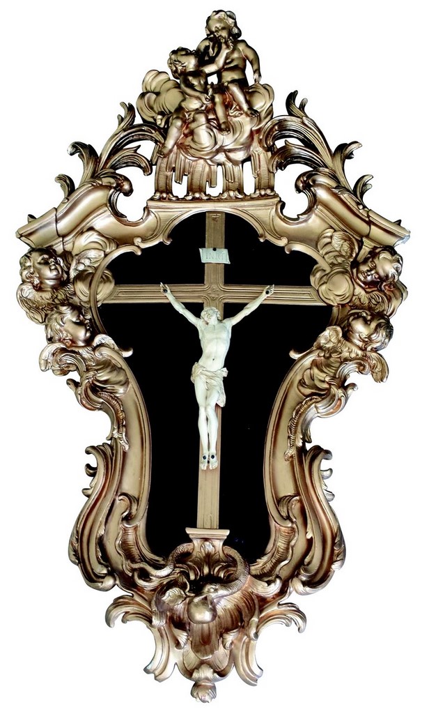 Important CHRIST en ivoire présenté dans un cadre en bois sculpté, redoré et ajouré à décor de feuillages, rinceaux et têtes d'angelots dans les nuages. XVIIIème siècle