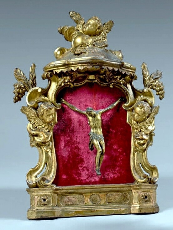 Christ en bronze doré dans un encadrement richement sculpté en bois doré orné d'un dais têtes d'angelots raisins