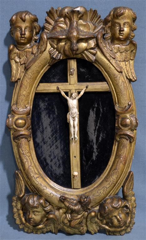 CHRIST en ivoire sculpté avec memento mori dans un encadrement sculpté et doré à décor d'angelots