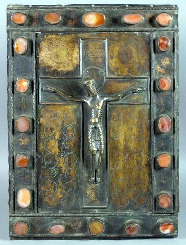 Grande plaque rectangulaire en cuivre. Au centre sur une croix est fixé un Christ en bronze fondu, la ceinture du périzonium ornée d'une perle de verroterie rouge