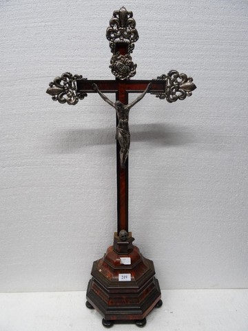 Sur une croix plaquée d’écaille fleurdelysée d’éléments estampés, un Christ en bronze argenté. 