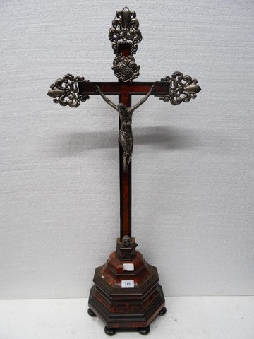 Sur une croix plaquée d’écaille fleurdelysée d’éléments estampés, un Christ en bronze argenté.